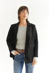 Blazer beige de tela agamuzada, corte recto y solapas clásicas.