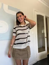 Remera de hilo tejido a rayas horizontales color beige y negro, de mangas cortas y corte suelto.