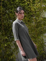 Vestido camisero verde seco de corte holgado, con cuello camisero, mangas 3/4 y cierre frontal con botones.