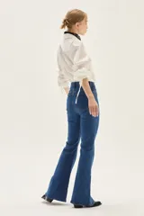 Jean acampanado de tiro alto, color azul medio, confeccionado en denim con un pequeño porcentaje de elastano.