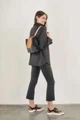 Sobrecamisa negra de textura simil cuero, con cuello camisero, cierre frontal con botones, mangas largas con puños abotonados, dos bolsillos con solapa en el pecho y corte recto.