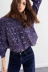 Blusa amplia de mangas largas y cuello redondo, estampada con detalles de lurex, punto smock en el frente y frunces en la espalda.