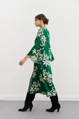 Vestido midi verde con estampado de hojas color crema, escote en V y mangas 3/4 amplias.