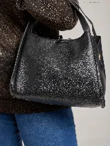 Bolso tipo tote color crema, con doble asa de hombro y logo de la marca grabado en el frente.