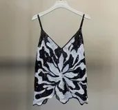 Top de fiesta negro con lentejuelas rosas y plateadas, escote en V y tirantes finos.