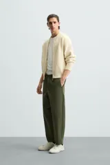 Pantalón verde militar de corte carrot fit, confeccionado en tejido de algodón. Cuenta con cintura elástica ajustable con cordón, bolsillos frontales y un bolsillo trasero de plastrón.