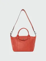 Bolso tote Longchamp modelo Le Pliage Cuir S, color naranja, confeccionado en cuero, con doble asa corta y correa larga extraíble.