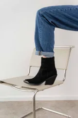 Bota corta de cuero vacuno color negro, con punta metálica plateada, taco de 7cm y suela de caucho antideslizante.