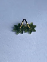 Par de aros colgantes con forma de estrella verde y aro dorado.