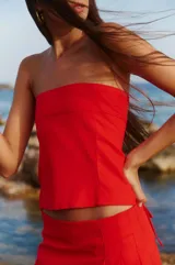 Top strapless rojo confeccionado en lino y rayón, con elástico y lazo para atar en la espalda.