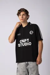 Remera tejida color crudo con cuello tipo chomba en V, mangas cortas con rayas negras y estampado con letras en el frente. Confeccionada en hilado de algodón.