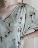 Vestido negro de corte recto, largo midi, con escote en V y mangas cortas.