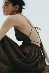 Vestido midi marrón con escote en V, tirantes finos ajustables y espalda descubierta con lazadas.
