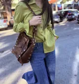 Camisa color verde lima confeccionada en lino, de corte holgado, con cuello camisero, mangas largas abullonadas con puños elásticos y cierre frontal con botones.