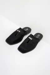 Zuecos con estampado animal print en blanco y negro, con tira ancha de cuero negro y aplique metálico.