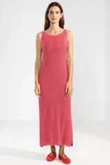 Vestido largo tejido en jersey fucsia, con escote redondo y abertura lateral.