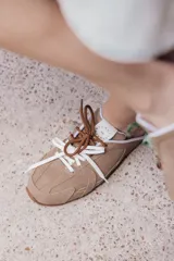 Zuecos color tostado de cuero con cordones de colores.