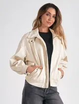 Campera bomber color beige de eco cuero, marca Elan. Tiene cuello con solapa y botón a presión, cierre metálico central, bolsillos delanteros con solapa y botón a presión, y ruedo trasero elastizado.