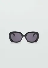 Lentes de sol negros con diseño cuadrado y montura de pasta hecha con residuos post-industriales reciclados de procesos de fabricación de gafas de policarbonato.