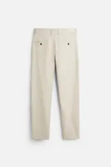 Pantalón slim fit negro confeccionado en tejido con elasticidad en ambas direcciones. Cuenta con bolsillos frontales y traseros de vivo con botón. Cierre frontal con cremallera y botón.