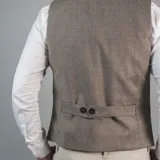 Chaleco de vestir marrón claro con textura de espiga, cuello en V, cierre frontal con botones y bolsillos ribeteados.