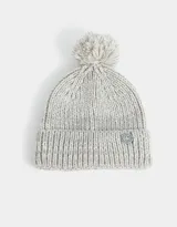 Gorro de lana tejido color gris claro, con pompón en la parte superior y etiqueta circular con logo en el borde inferior.