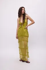 Vestido largo color verde oliva brillante, con breteles finos y escote regulable. Presenta volados en los recortes de la falda.