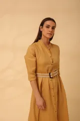 Vestido midi color mostaza, estilo camisero, con cuello mao, mangas 3/4 y cinturón trenzado.