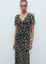 Vestido midi negro con estampado de flores blancas, escote en V y mangas cortas con volados.