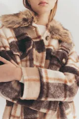 Tapado largo con estampado a cuadros en tonos marrón, beige y blanco. Presenta cuello con solapa y detalle de piel sintética.