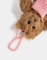 Llavero con forma de oso de peluche marrón con cartera tejida rosa y gancho metálico rosa.