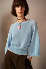 Jersey celeste de punto con cuello redondo y mangas tres cuartos amplias.
