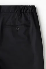 Short negro de sarga de algodón suave, con elástico en los laterales de la cintura, cierre con botón, bolsillos al bies y bolsillos de atrás ribeteados con botón. Corte estándar.