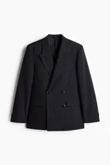 Blazer negro de doble botonadura con solapas de pico, bolsillo superior, bolsillos delanteros ribeteados con solapa, tres bolsillos interiores, botones decorativos en los puños y abertura doble atrás.