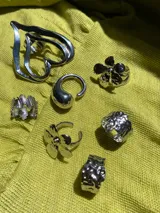 Anillo plateado regulable de acero inoxidable con forma irregular y superficie texturizada.