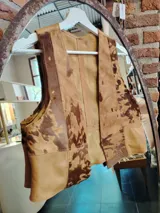 Chaleco de cuero color marrón con manchas marrones oscuras, con forro interno liso color beige.