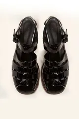 Sandalias de cuero color borgoña con tiras entrecruzadas, hebilla lateral y taco de madera.