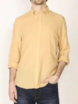 Camisa color amarillo claro de lino y algodón, con cuello abotonado, manga larga con puños abotonados y bolsillo en el pecho. Corte clásico.
