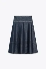 Falda midi de tiro alto confeccionada en denim azul oscuro. Presenta costuras a contraste y cierre lateral con cremallera metálica.