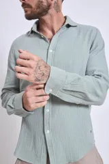 Camisa de manga larga color gris oscuro, con cuello clásico y cierre frontal con botones.