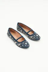 Bailarinas planas de gamuza azul marino con tira de terciopelo en el empeine. El cuerpo del zapato está completamente cubierto con apliques y bordados de perlas y cristales en tonos blancos y dorados.