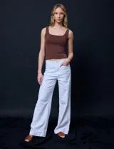 Pantalón de jean blanco de pierna ancha, tiro alto, pretina con pasadores, botón y cierre. Delantera y trasera con bolsillos.