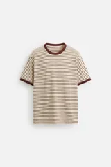 Camiseta de manga corta con cuello redondo y corte regular. Diseño a rayas horizontales en color crema y marrón, con ribete marrón en cuello y mangas.