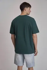 Remera verde oscuro de corte holgado y mangas cortas.