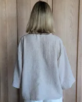 Blusón de manga 3/4 con cuello en V, color crudo.