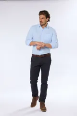Pantalón de vestir azul marino, de corte recto, con bolsillos laterales y traseros. Se ajusta a la cintura con cinturón de cuero marrón.