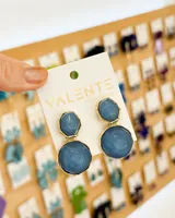 Aros colgantes con dos piezas circulares de color celeste con borde dorado.