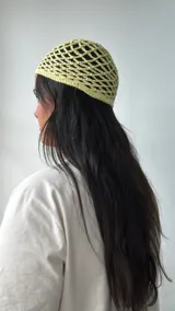Gorro tipo bandana de crochet color amarillo pastel.