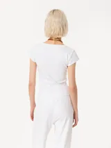 Remera blanca de algodón pima con escote en U, mangas cortas y logo bordado en la espalda.