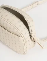 Bandolera negra de cuerina con bolsillo frontal con tag de metal, correa regulable, cierre superior y tirador de material principal.